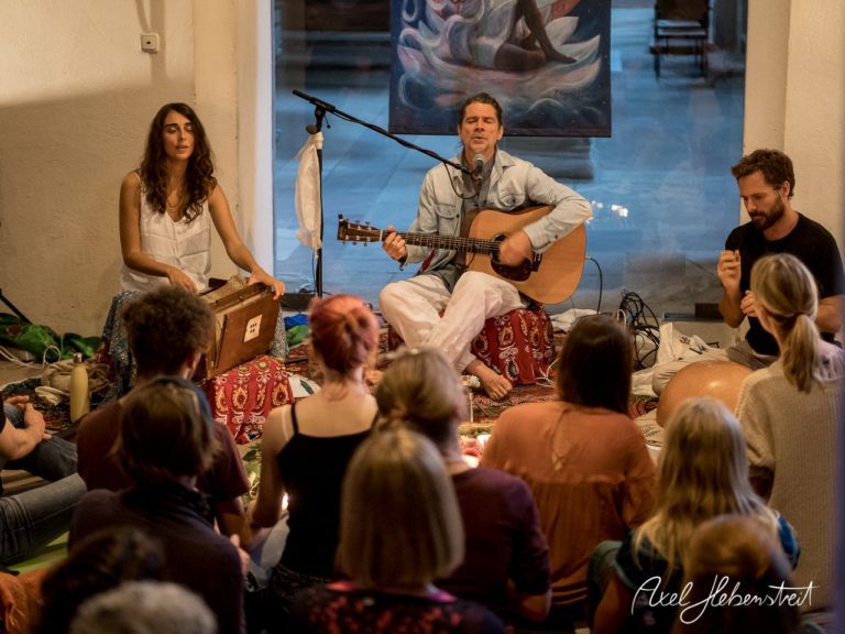 Ein musikalisches Konzert mit Gesang und Instrumenten in einer spirituellen Atmosphäre, umgeben von Gästen. – © Axel Hebenstreit