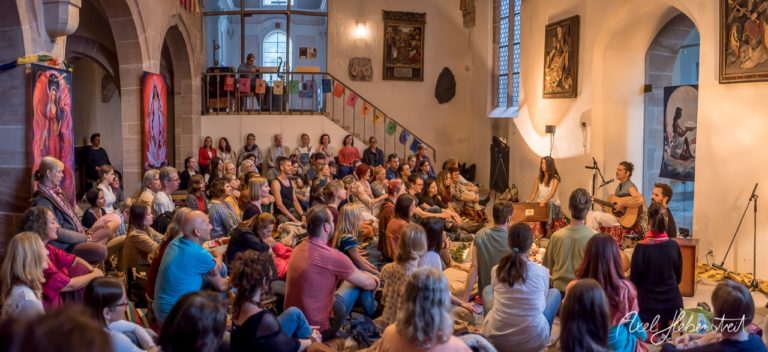 Ein Publikum lauscht gespannt einem akustischen Konzert in einer inspirierenden, mit Kunstwerken geschmückten Umgebung. – © Axel Hebenstreit