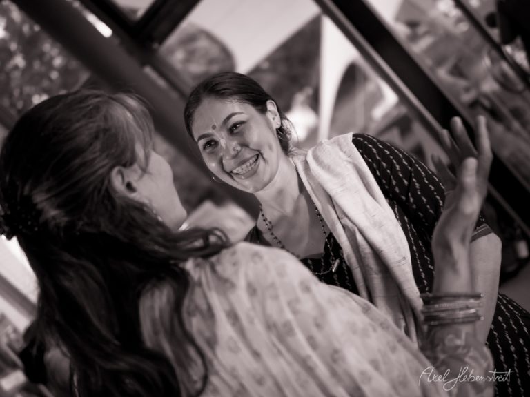 Zwei Frauen in traditioneller bayerischer Tracht lachen sich herzlich an, schwarzweißes Porträt – © Axel Hebenstreit