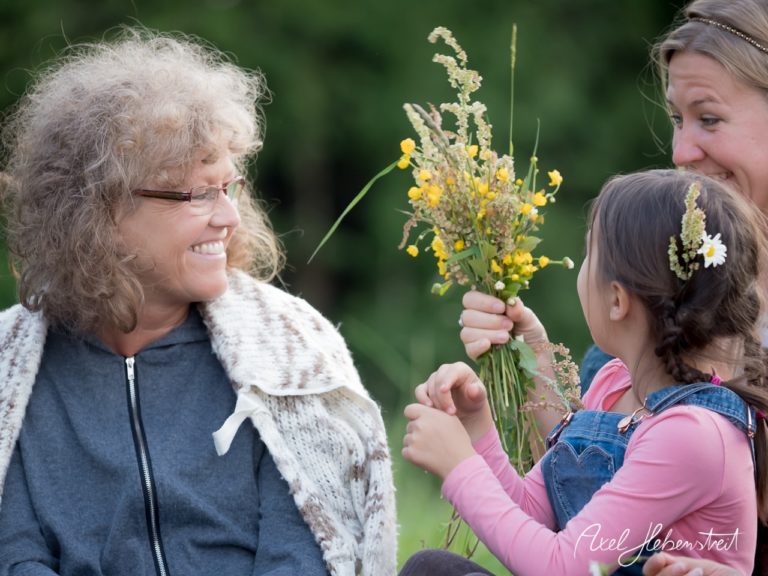 Fröhliche Mutter und Tochter genießen die Zeit im Freien, umgeben von bunten Wildblumen – © Axel Hebenstreit