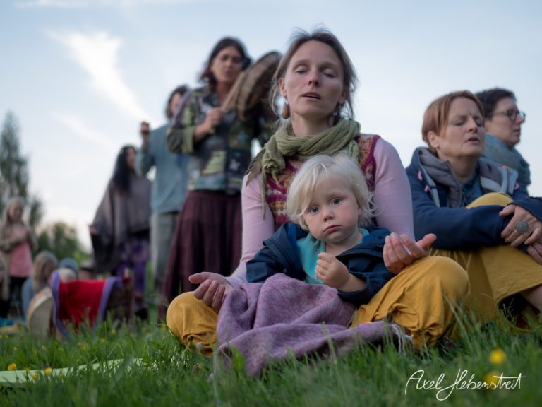 Meditative Szene mit einer Frau und einem Kind in entspannter Atmosphäre während eines Festivals im Freien. – © Axel Hebenstreit