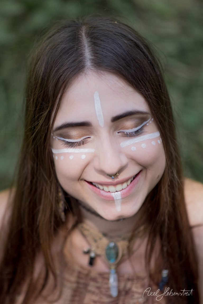Lächelnde Frau mit weißem Festival-Bodypainting im Freien – © Axel Hebenstreit