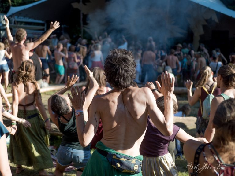 Festivalbesucher tanzen und feiern ausgelassen unter blauem Zelt bei sommerlichem Wetter – © Axel Hebenstreit