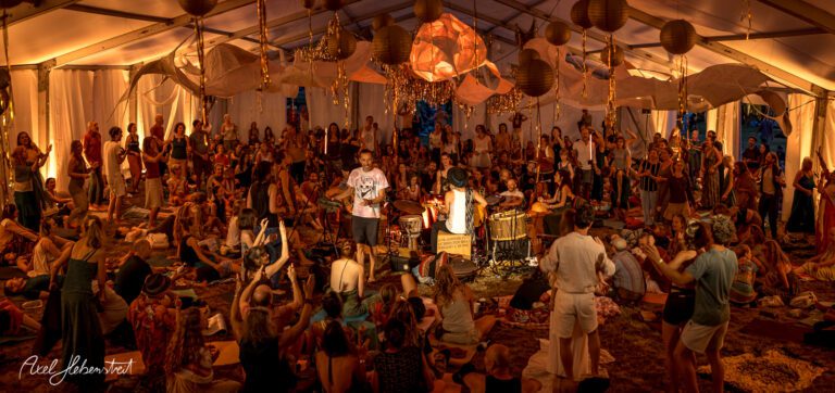 Belebte Festivalatmosphäre mit Menschen, die einem Auftritt im Zelt lauschen und feiern – © Axel Hebenstreit