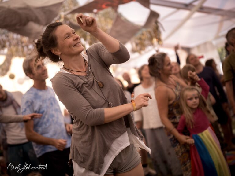 Frau tanzt mit Freude inmitten einer lebhaften Festivalatmosphäre – © Axel Hebenstreit