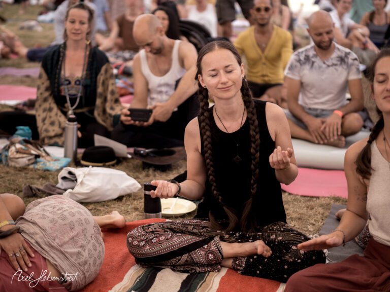 Meditierende Menschen in entspannter Atmosphäre während eines Festivals im Freien – © Axel Hebenstreit