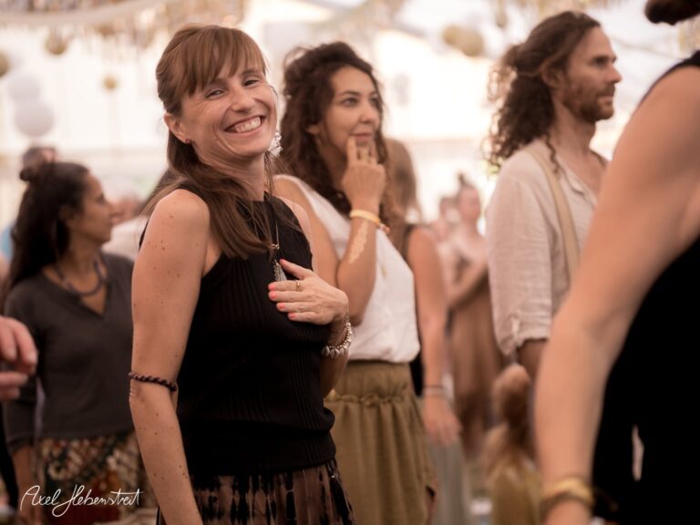 Lächelnde Frau in lebhafter Festivalatmosphäre, umgeben von Menschen, die die Musik genießen – © Axel Hebenstreit