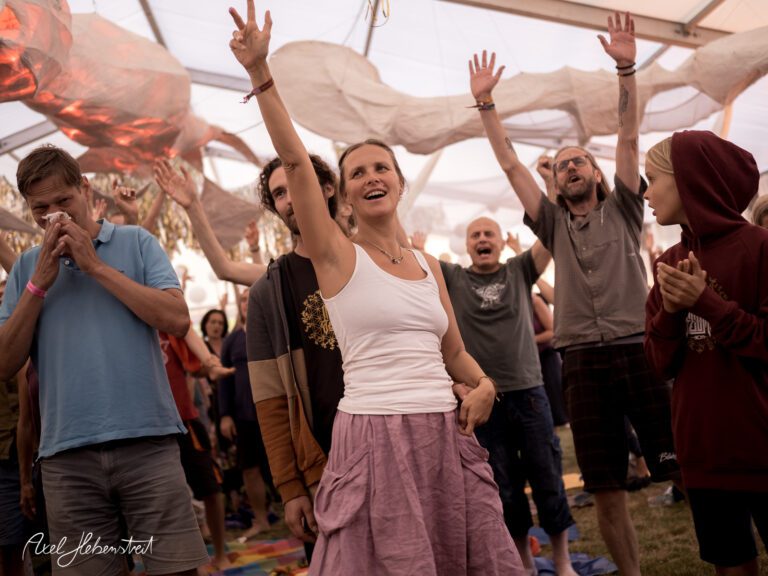 Menschen feiern in einem Zelt, voller Freude und Energie, während sie zu Musik tanzen – © Axel Hebenstreit