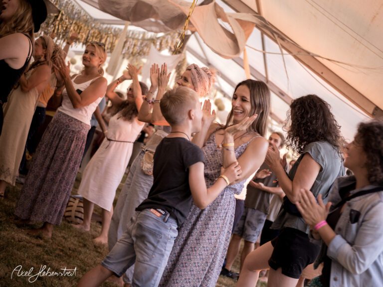 Tanzende Menschen unter einem Zelt bei einem Festival, fröhliche Stimmung und Gemeinschaftsgefühl. – © Axel Hebenstreit