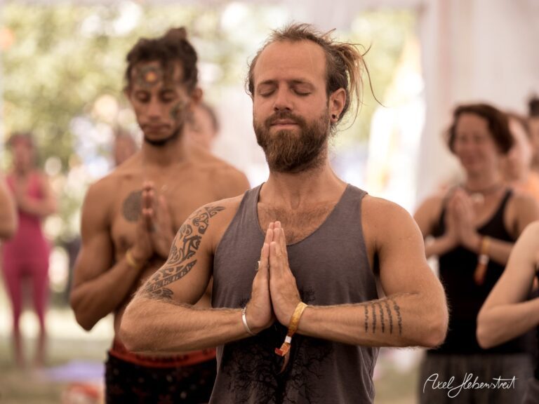 Meditierende Teilnehmer bei einem Yoga-Festival in entspannter Atmosphäre unter einem Zelt – © Axel Hebenstreit.