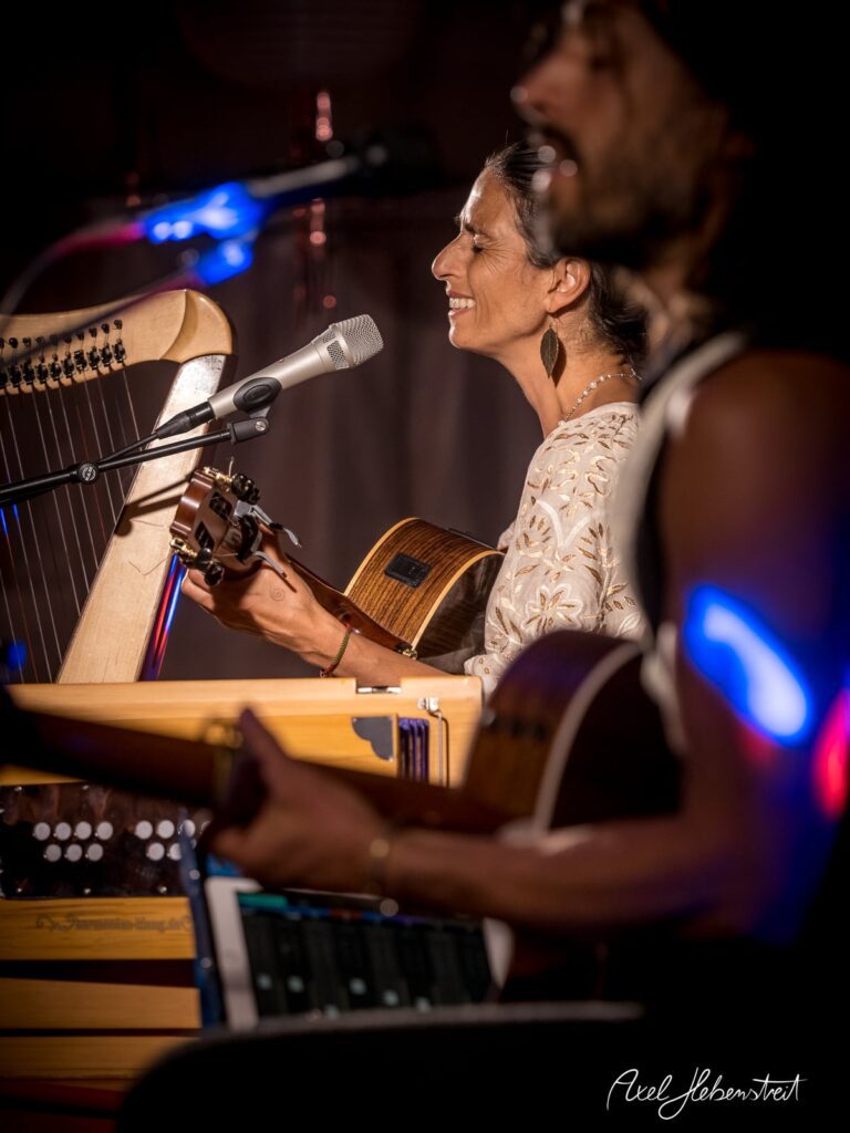 Zwei Musiker, eine Harfenistin und ein Gitarrist, performen harmonisch auf der Bühne in einem stimmungsvollen Setting – © Axel Hebenstreit