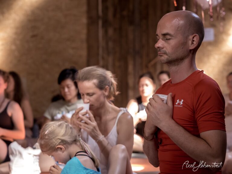 Meditative yogische Versammlung mit Teilnehmern in einem Licht durchfluteten Raum – © Axel Hebenstreit