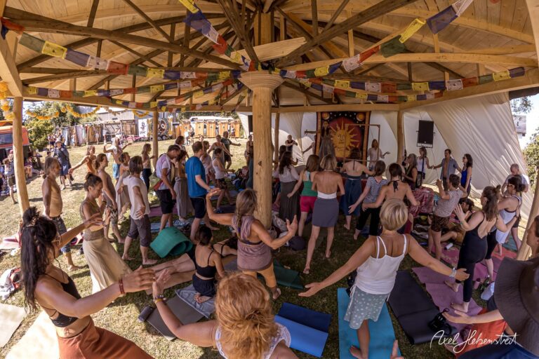 Gruppensitzung in einem Zelt bei einem Festival, Teilnehmer üben Yoga und fördern Gemeinschaftsgefühl – © Axel Hebenstreit