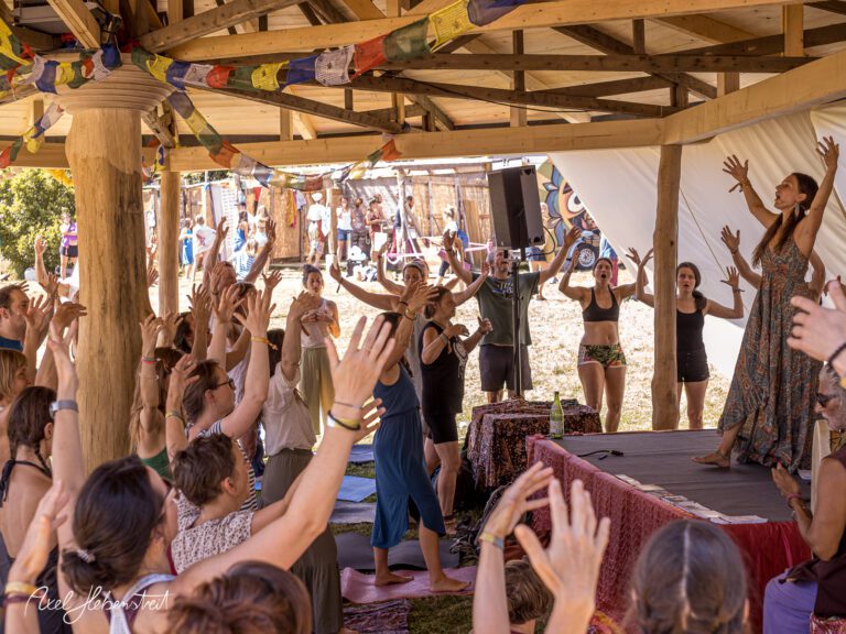 Eine Gruppe von Menschen tanzt und feiert voller Freude unter einem Pavillon auf einem Festival – © Axel Hebenstreit