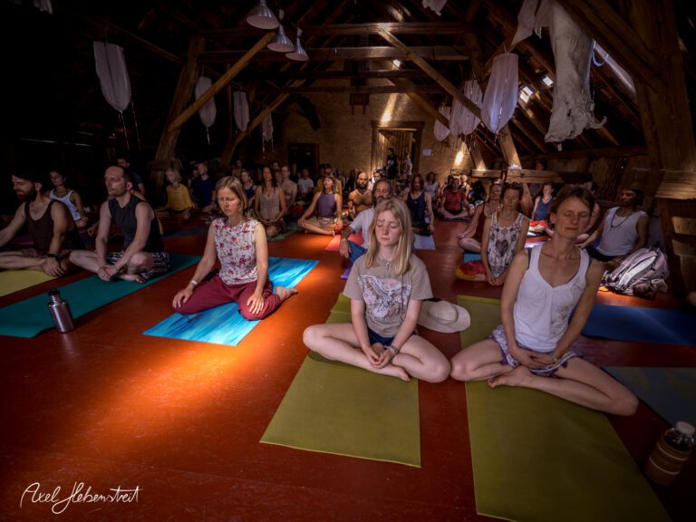 Gruppensitzung mit meditierenden Menschen in einem lichtdurchfluteten, rustikalen Raum – © Axel Hebenstreit