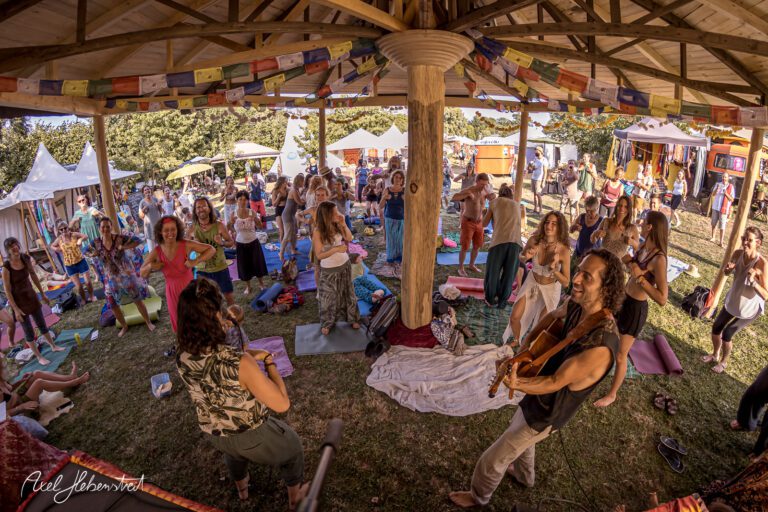 Menschen tanzen und feiern im Freien während eines Festivals in einem Pavillon – © Axel Hebenstreit