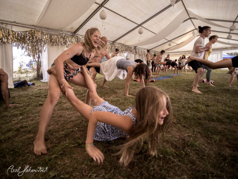 Spaßige Kinder und Erwachsene beim Spielen und Tanzen in einem Festivalzelt – © Axel Hebenstreit