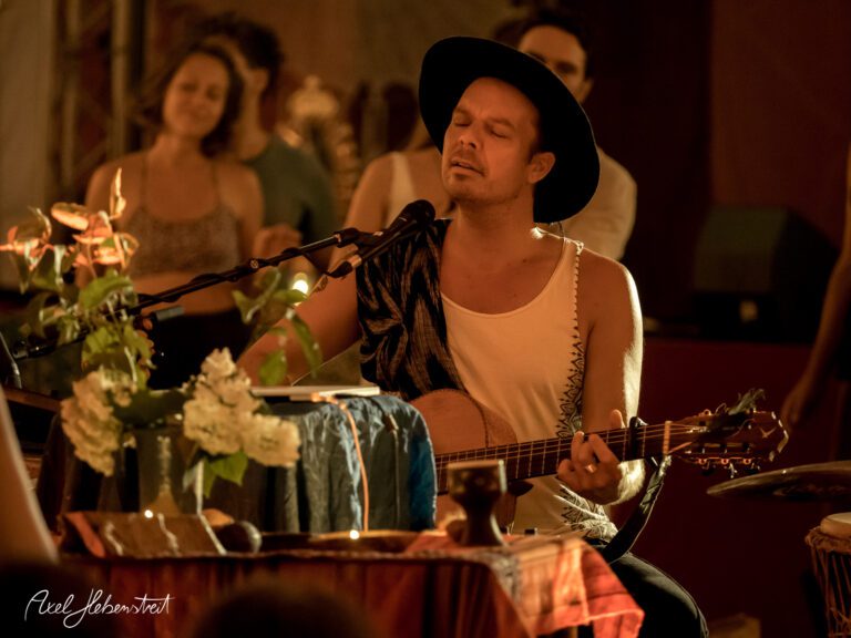 Ein Singer-Songwriter spielt gefühlvoll Gitarre in einer stimmungsvollen, intimen Umgebung – © Axel Hebenstreit