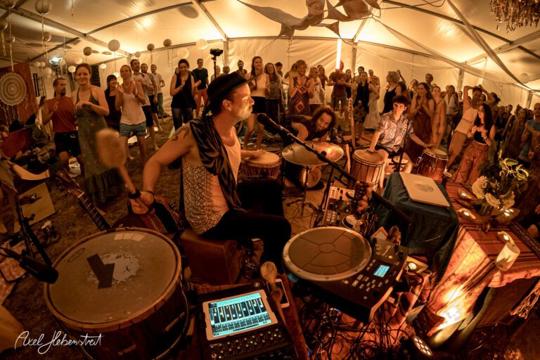Trommler im Zelt während eines Festivals, umgeben von begeistertem Publikum – © Axel Hebenstreit