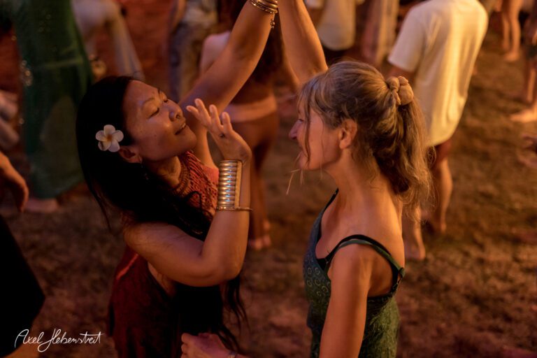 Zwei Frauen tanzen leidenschaftlich auf einem Festival in warmem Licht – © Axel Hebenstreit