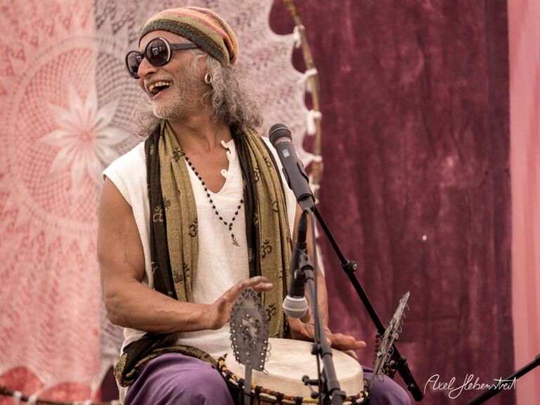 Ein glücklicher Musiker spielt auf einer Trommel und genießt die Atmosphäre eines Festivals. – © Axel Hebenstreit