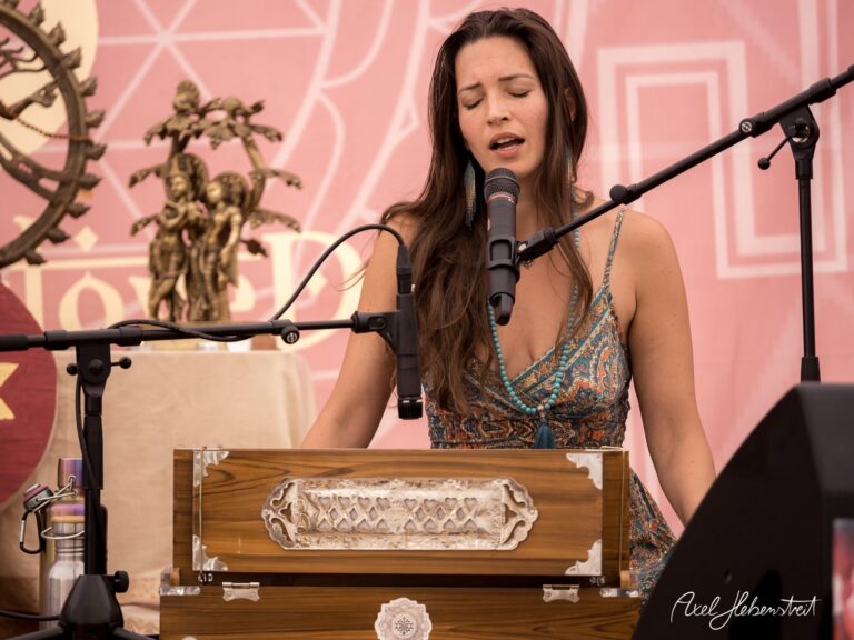 Frau singt gefühlvoll am Mikrofon, begleitet von einem Harmonium auf einem Festival. – © Axel Hebenstreit