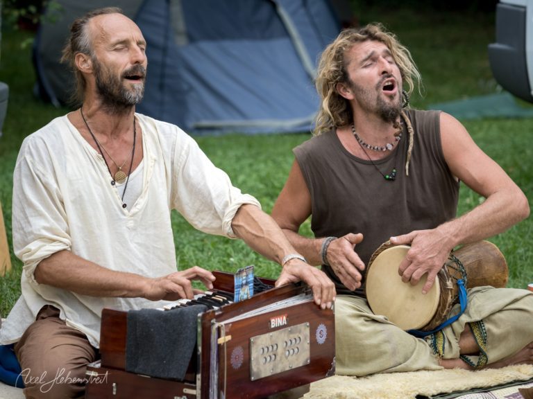 Zwei Musiker spielen leidenschaftlich im Freien, umgeben von Natur und Festivalatmosphäre – © Axel Hebenstreit