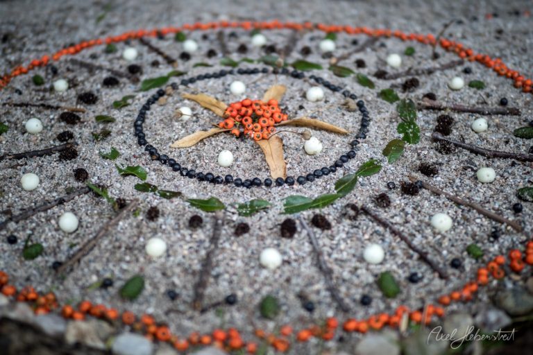 Kunstvolle Mandala-Gestaltung aus Naturmaterialien auf einem Gehweg in Bayern – © Axel Hebenstreit