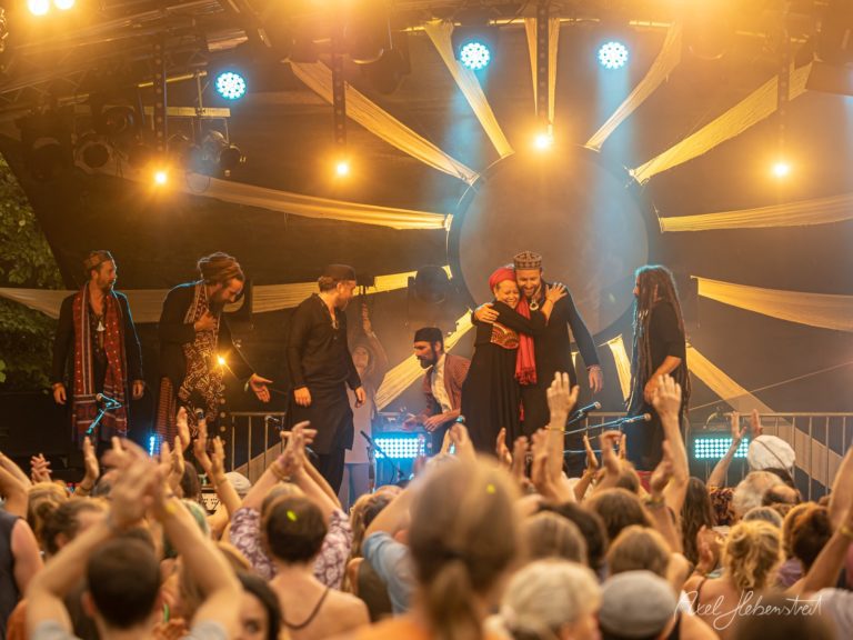 Live-Performance auf einem Festival mit tanzenden Menschen und einer festlichen, energetischen Atmosphäre – © Axel Hebenstreit