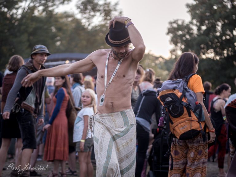 Tanzender Mann auf einem Festival, umgeben von fröhlichen Menschen in einer lebhaften Atmosphäre – © Axel Hebenstreit