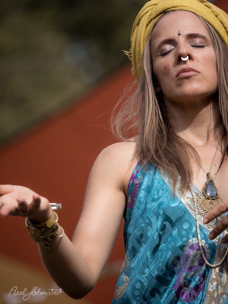 Eine spirituelle Person mit geschlossenen Augen und Kopfwrap, die in einer harmonischen Pose meditativ wirkt – © Axel Hebenstreit