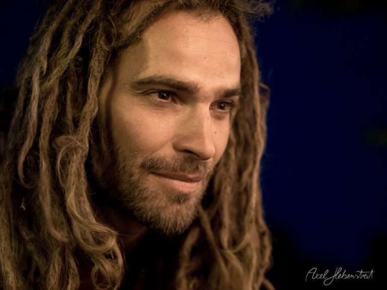 Portrait eines Mannes mit Dreadlocks, der konzentriert und nachdenklich wirkt. – © Axel Hebenstreit