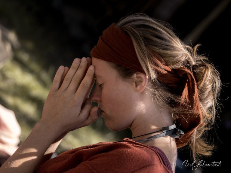 Frau meditiert in ruhiger Pose im Freien, während die Sonne sanft auf ihr Gesicht scheint – © Axel Hebenstreit