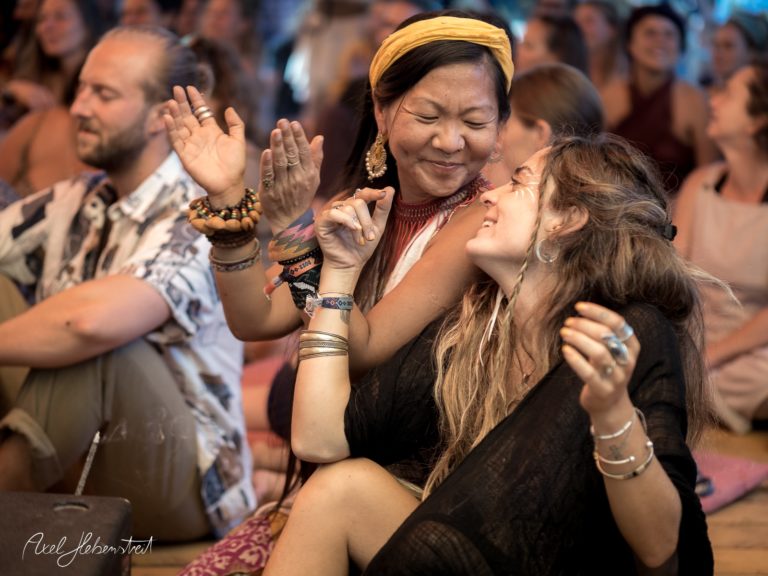 Zwei Frauen tanzen fröhlich zusammen auf einem Festival, umgeben von einer entspannten, festlichen Atmosphäre – © Axel Hebenstreit