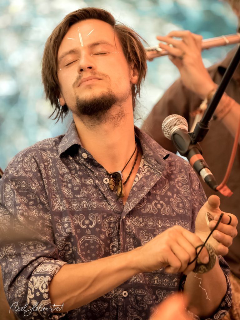 Ein musizierender Mann mit geschlossenen Augen und meditativer Ausstrahlung auf einem Festival – © Axel Hebenstreit