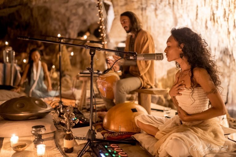 Meditative Atmosphäre bei einem Musik-Performance in einer Höhle, umgeben von Kerzenlicht und entspannten Menschen – © Axel Hebenstreit