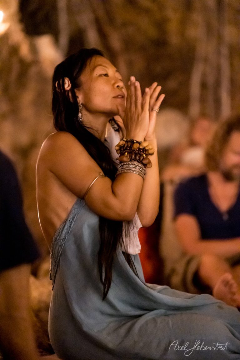 Eine Frau in einem blauen Kleid betet meditativ in einer warmen, intimen Atmosphäre. – © Axel Hebenstreit