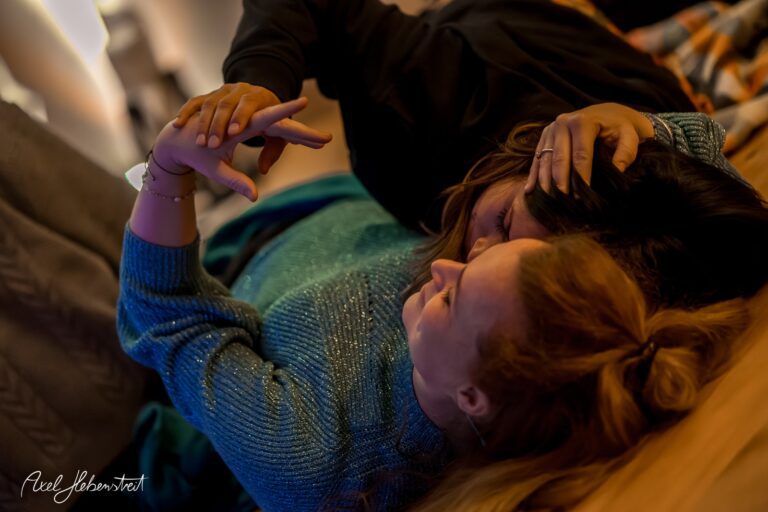 Zwei Frauen liegen eng umschlungen auf dem Boden und genießen einen intimen Moment der Zweisamkeit – © Axel Hebenstreit.