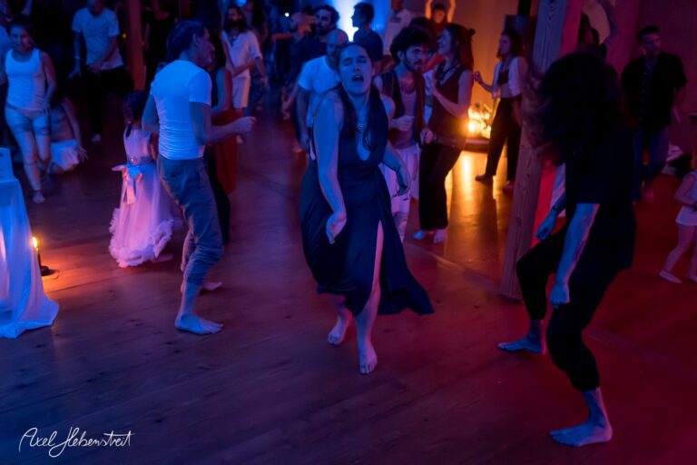 Tanzende Menschen in einem festlichen Ambiente mit stimmungsvollem Licht, die Freude und Energie ausstrahlen – © Axel Hebenstreit