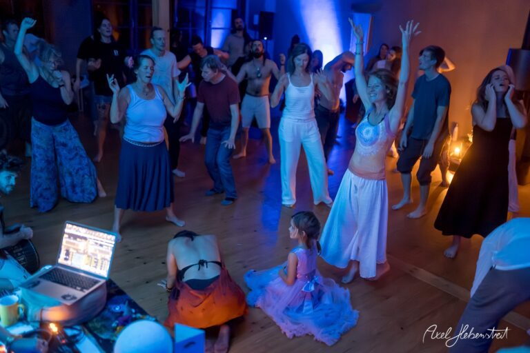 Tanzende Menschen in einem festlichen Raum schaffen ausgelassene Stimmung bei einer Yoga-Event – © Axel Hebenstreit