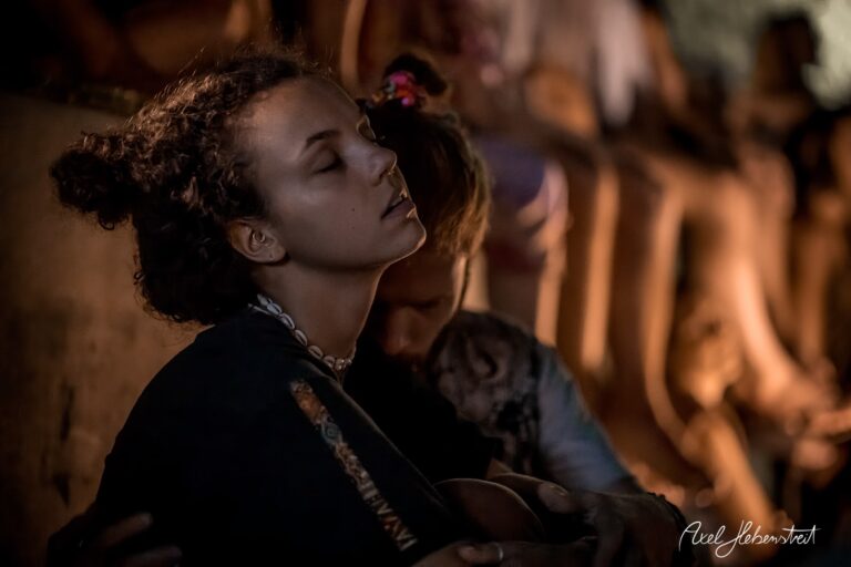 Intensive Momentaufnahme einer jungen Frau in meditativem Zustand, umgeben von Festivalbesuchern – © Axel Hebenstreit
