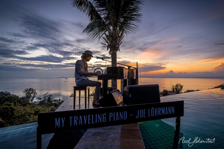 Ein Pianist spielt an einem infinity Pool mit Blick auf das Meer und beeindruckenden Sonnenuntergang – © Axel Hebenstreit