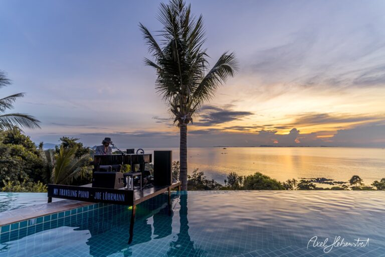 Ein Pianist spielt bei Sonnenuntergang am Rand eines Infinity-Pools mit Blick auf das Meer – © Axel Hebenstreit