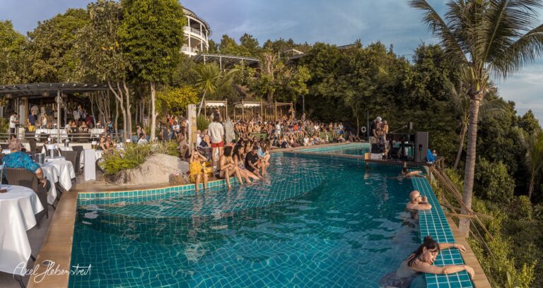 Bei einer lebhaften Poolparty genießen zahlreiche Menschen den sonnigen Tag in einer traumhaften Umgebung – © Axel Hebenstreit