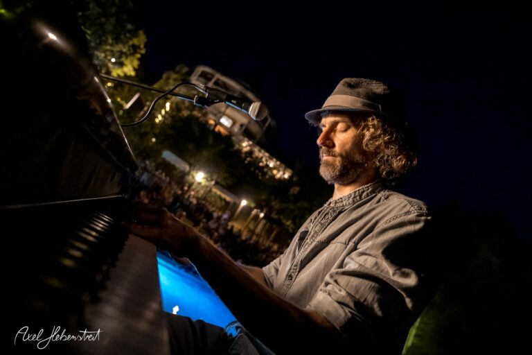 Ein Musiker spielt am Klavier unter dem Sternenhimmel, umgeben von einer entspannten Atmosphäre – © Axel Hebenstreit.