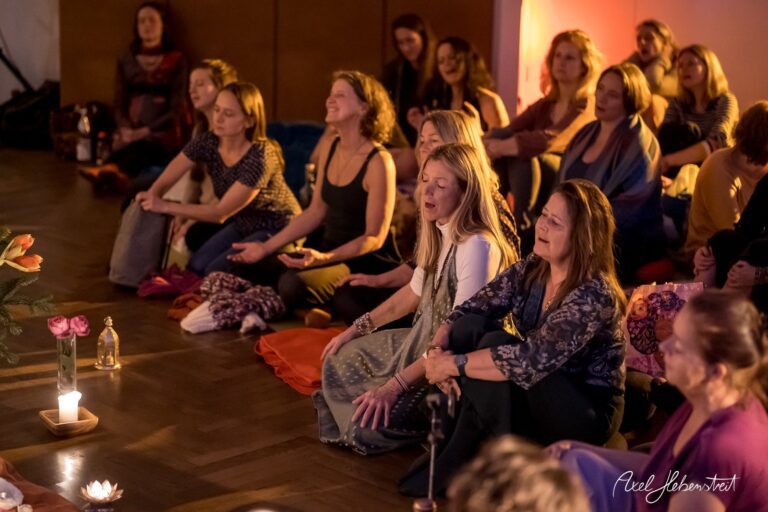 Frauen sitzen entspannt in einem Yogastudio und genießen eine meditative Musiksession – © Axel Hebenstreit