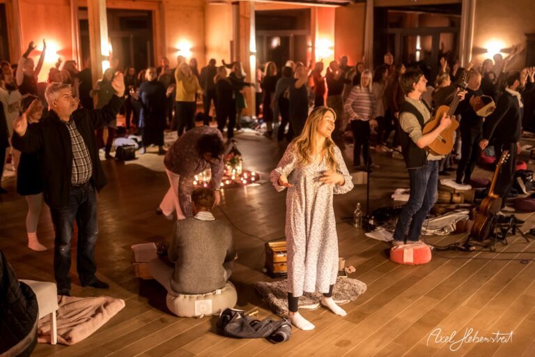 Gemeinschaftliche Yoga-Session mit Musik, Lichtern und Bewegung in einem einladenden Raum – © Axel Hebenstreit