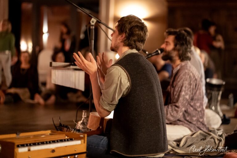 Zwei Musiker spielen in einem gemütlichen Raum, während eine Gruppe entspannt zuhört und die Atmosphäre genießt. – © Axel Hebenstreit