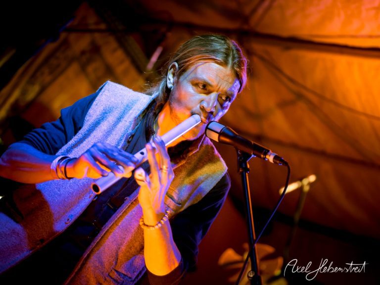 Ein Musiker spielt auf einer Flöte und schafft eine intime Atmosphäre bei einem Konzert. – © Axel Hebenstreit