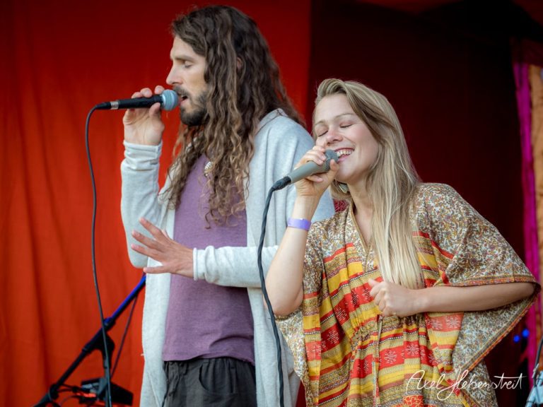 Ein Sänger und eine Sängerin performen leidenschaftlich auf einer Bühne während eines Festivals. – © Axel Hebenstreit